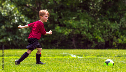 Youth Football Player Approaches Ball © J. Novack