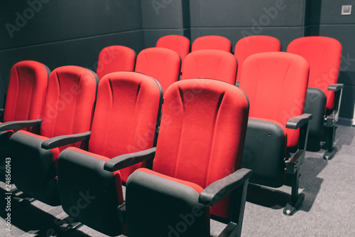 Cinema or movie auditorium with empty red seats or chairs