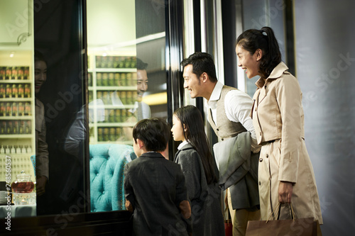 asian family looking into shop window