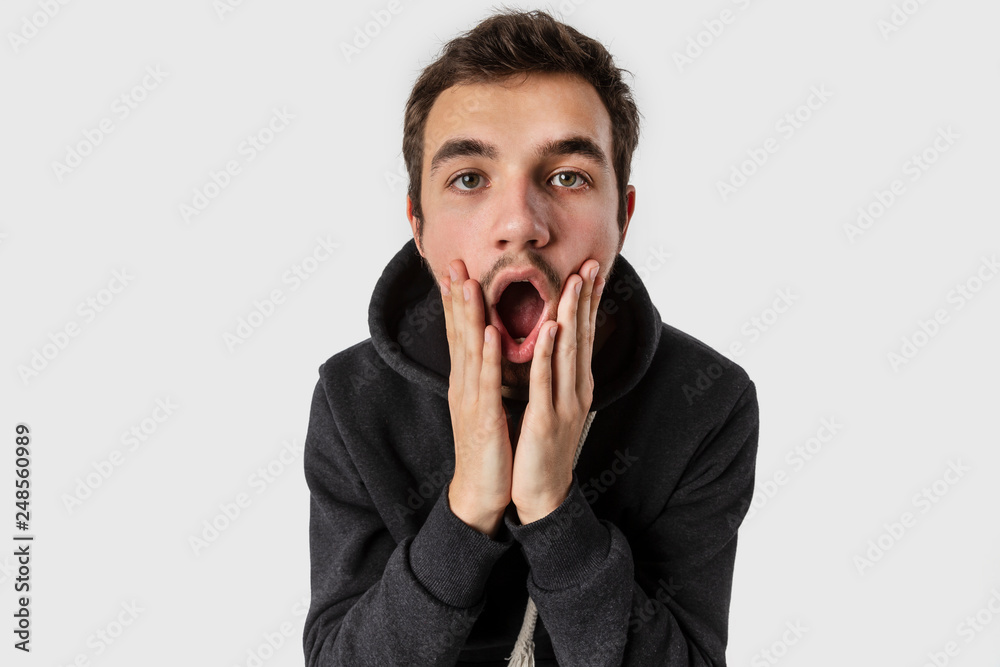 Surprised caucasian young man with arms on his cheeks. Isolated on white background. Surprise concept. Surprised caucasian young man with arms on his cheeks. Isolated on white background. Surprise concept.
