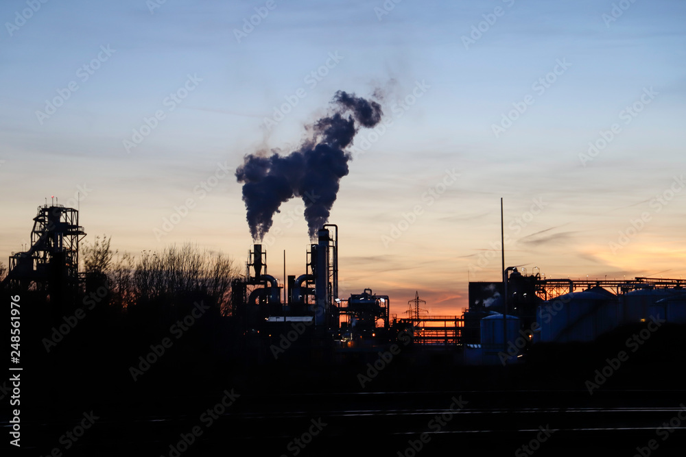 sunset with chimneys in an industrial zone of renewable energy