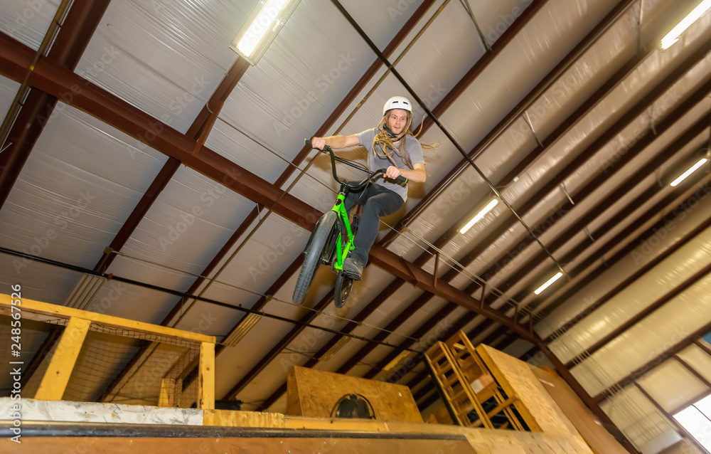 Man jumping and riding on a BMX bicycle at an extreme sports park