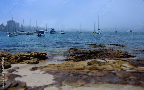 Yachts in North Harbour at Fourty Baskets Beach on a foggy day. Manly in the background. © katacarix