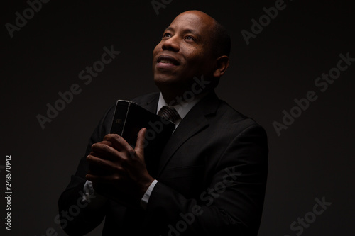 African American Christian Man Holding the Word of God, the Bible, The Scriptures
