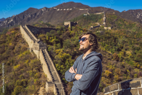 Canvas Print Happy cheerful joyful tourist man at Great Wall of China having fun on travel smiling laughing and dancing during vacation trip in Asia