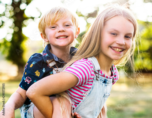 Girl giving her brother a piggyback ride photo