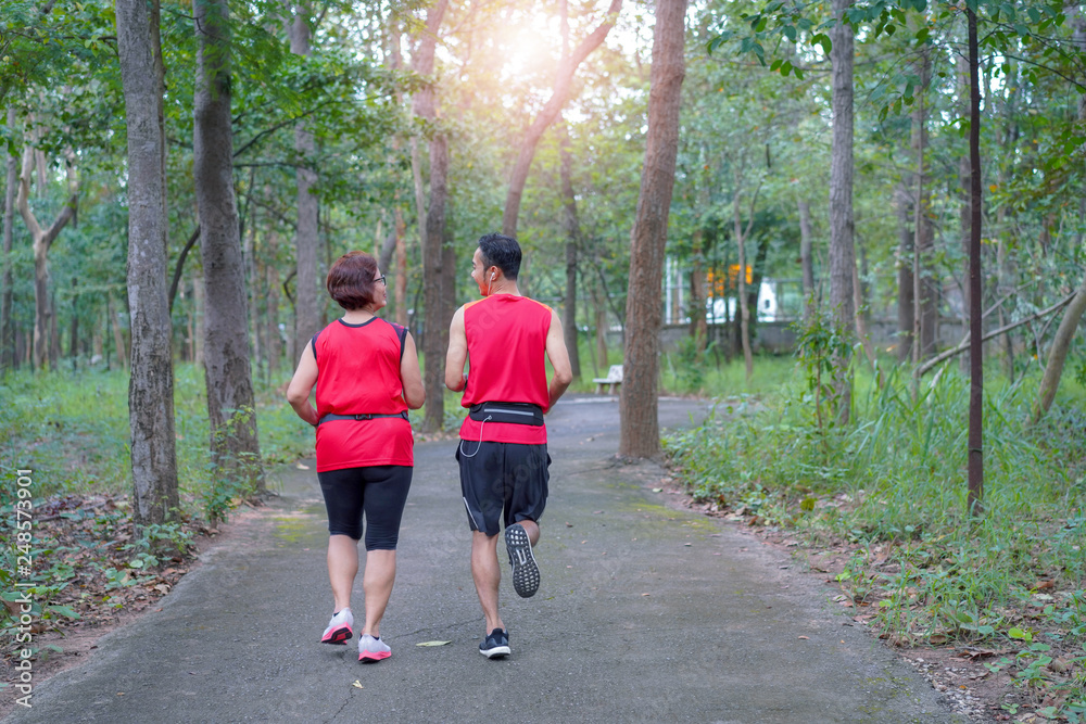 Happy asian mother and son jogging running in the park, Elderly care exercise sport activity concept