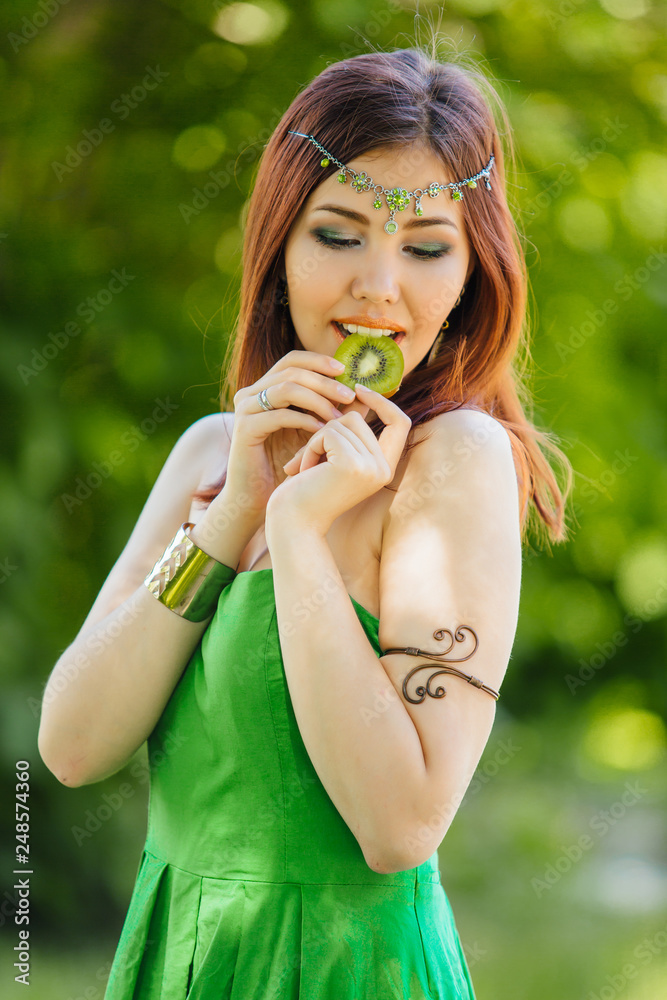 Beautiful young asian woman biting slice of kiwi Beautiful young asian woman biting slice of kiwi