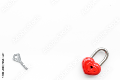 Valentine's day concept. Lock in shape of heart near key on white background top view copy space