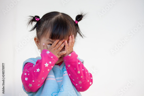 Tableau sur toile Cute asian baby girl closing her face and playing peekaboo or hide and seek with
