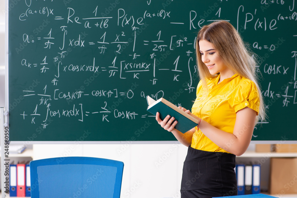 Young female student in front of the chalkboard Young female student in front of the chalkboard