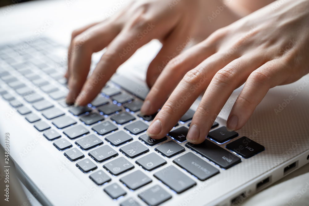Closeup image of hands using and typing on laptop keyboard in cafe Closeup image of hands using and typing on laptop keyboard in cafe