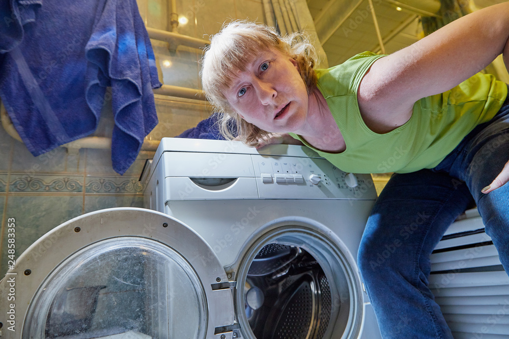 Housewife near washing machine doing selfie in the bath room Housewife near washing machine doing selfie in the bath room
