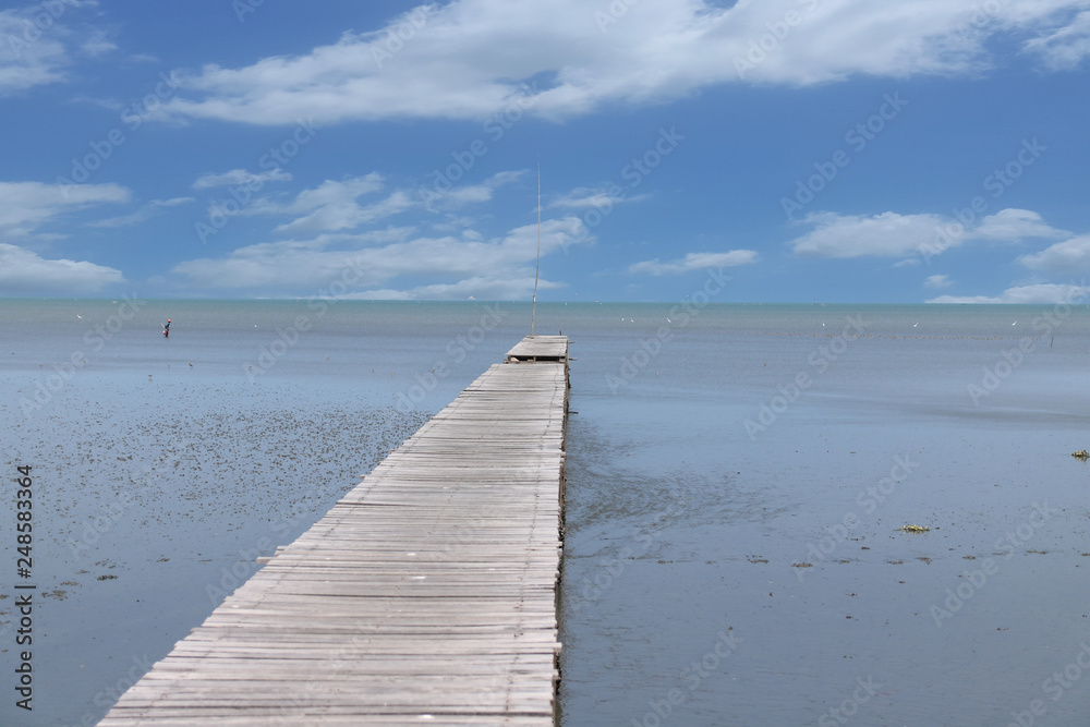 A wooden bridge that stretches to the sea on a clear day – Image A wooden bridge that stretches to the sea on a clear day – Image
