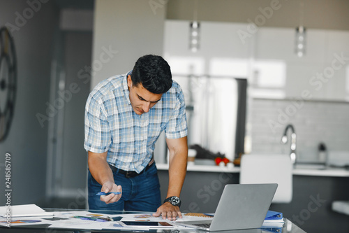 Handsome businessman in a office. Businessman in a blue shirt. Male with laptop. Young boy working photo