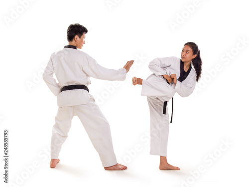 Two young Asian martial art fighters exchanging strikes, full length portrait, isolated background