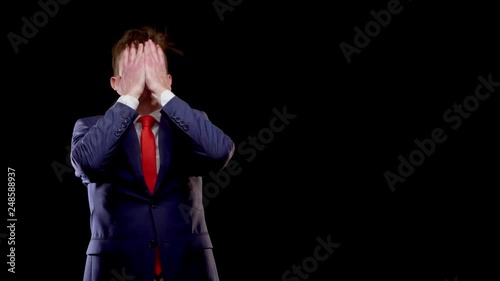 A young man of Caucasian appearance in a business suit, a white shirt with a red tie, in anger, clutching his head, Restrepo hair photo