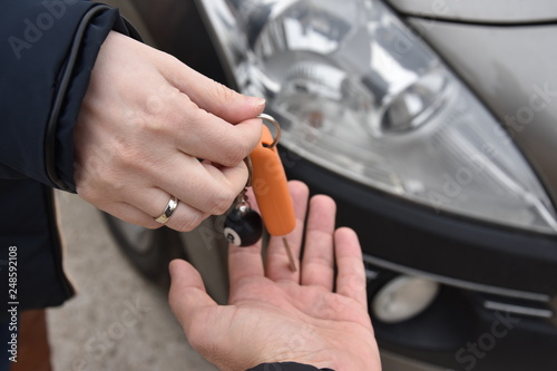 car sales. one person sells car and gives the key to the new owner - Image