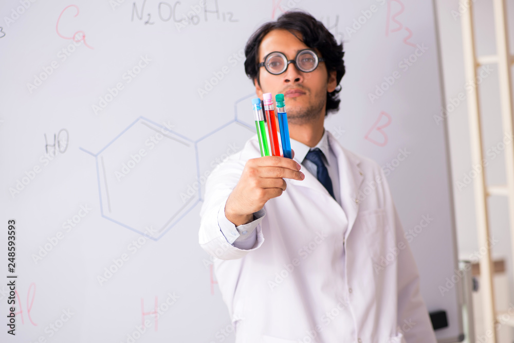 Young funny chemist in front of white board Young funny chemist in front of white board