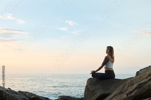 Woman Practicing Yoga in the Nature. Meditating Outdoors © glazunoff
