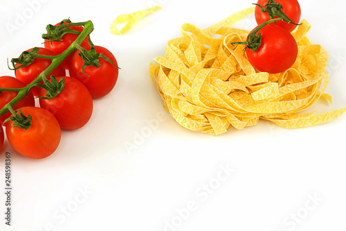 Fettuccine pasta (from fettucci - ribbons), tomato. One of the most popular types of pasta. Looks like a tagliatelle. Culinary ingredient, selective focus, close-up.