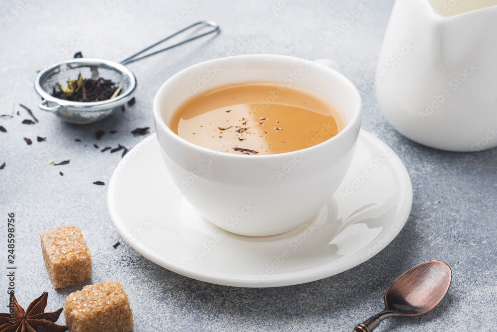 Cup of tea with milk, brown anise sugar on a grey table. Cup of tea with milk, brown anise sugar on a grey table.