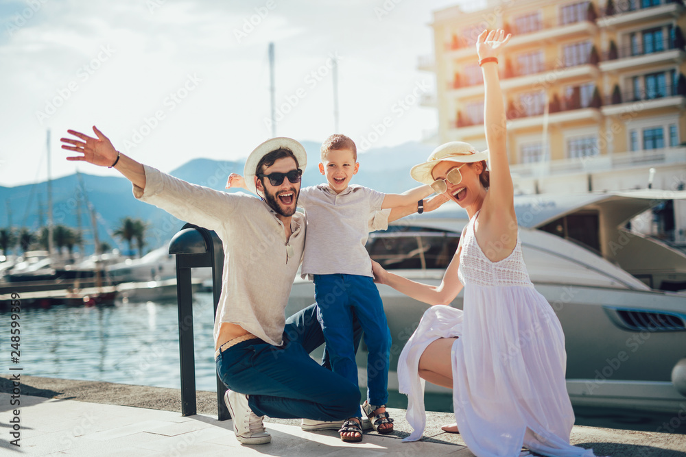 Happy family on holiday in front of boat having fun