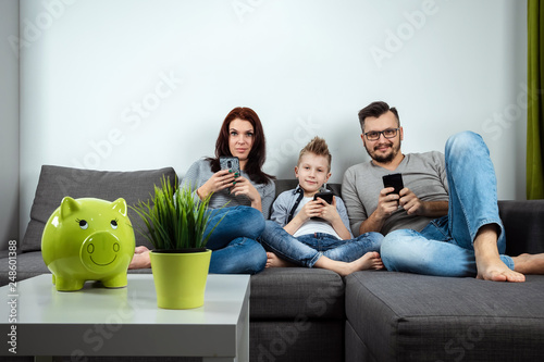 Modern family, everyone is sitting in smartphones than the passionate. The concept of harmfulness of modern gadgets, the detrimental effect on communication, the lack of live communication. photo