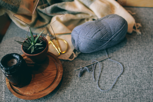 Home decoration Nordic interior details and Cosy place on grey sofa by the warm pompon blanket and cushions vase and candle on the wooden tray