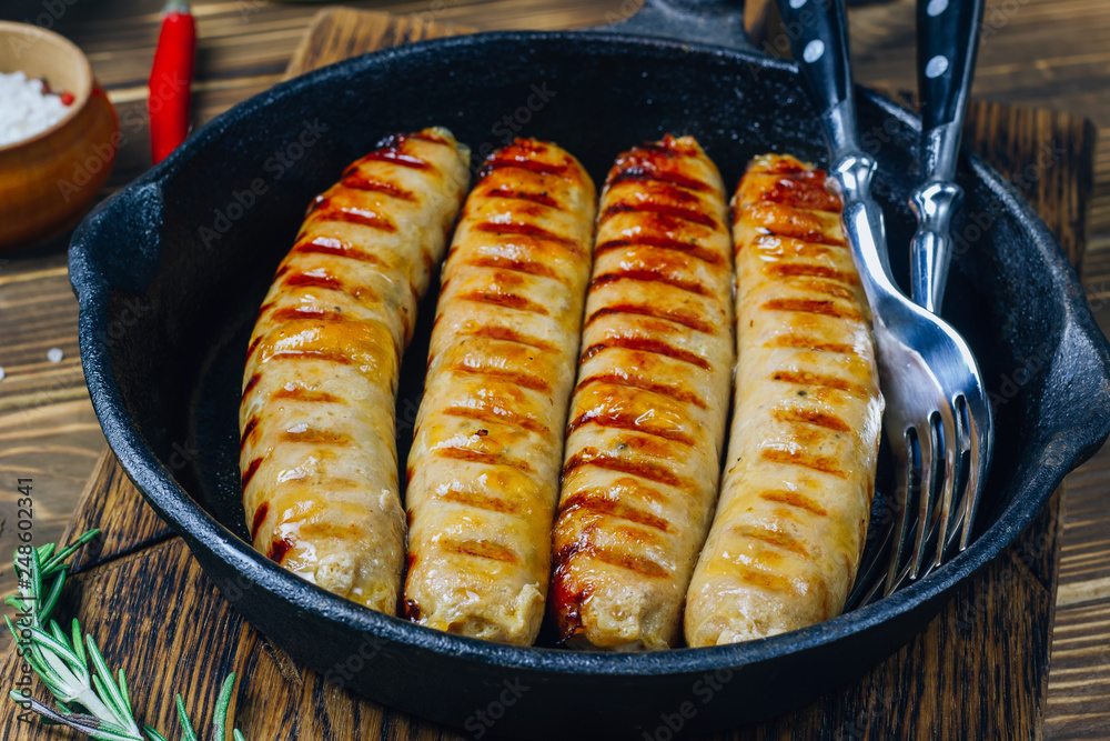 Tyrolean sausages with rosemary in a cast iron pan Tyrolean sausages with rosemary in a cast iron pan