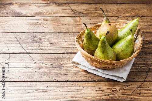 Fresh juicy Pears Conference in a basket on a wooden rustic background. photo