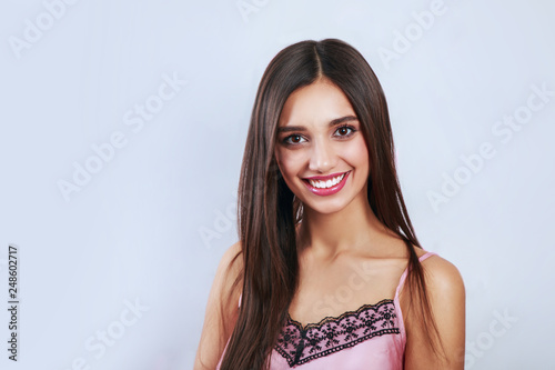 The young beautiful woman's portrait with happy emotions on gray background