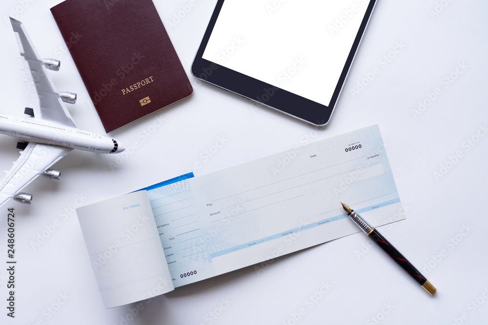 Mockup cheque book,pen,digital tablet ,passport and airplane model isolated on white background.. Trip and travel concept. Mockup cheque book,pen,digital tablet ,passport and airplane model isolated on white background.. Trip and travel concept.