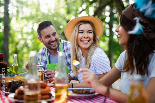 Photography Group of happy friends eating and drinking beers at barbecue dinner