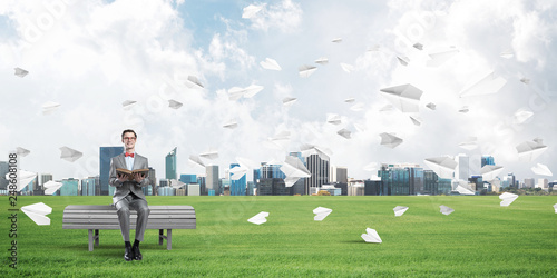 Young businessman or student studying the science and paper planes flying around