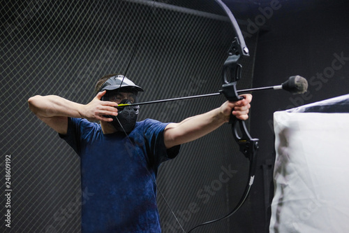 Man with crossbow arrows bow. The Archer takes aim, sharpshooter. Crossbow club. photo