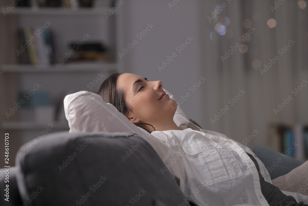 Woman resting comfortably on a couch in the night Woman resting comfortably on a couch in the night
