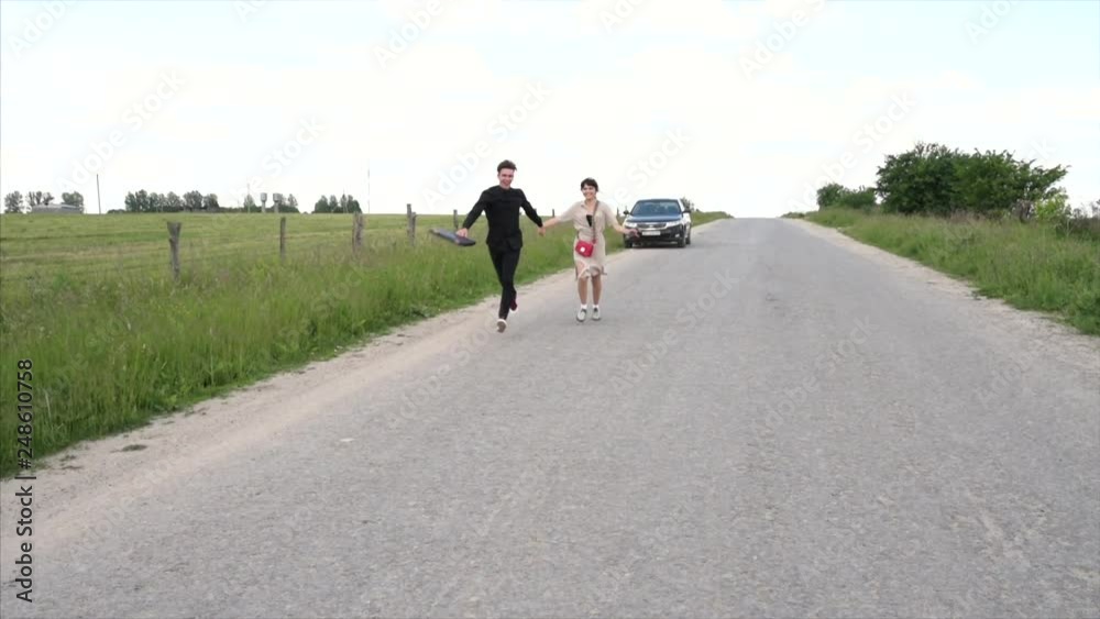 Cute young guy standing next to a beautiful girl on a green background behind a city