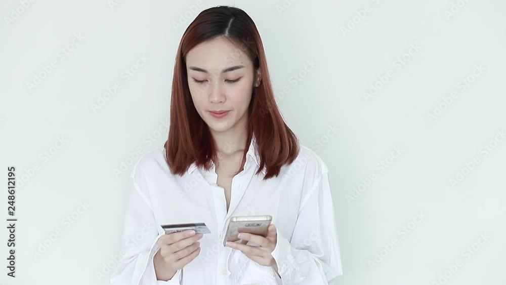 Sexy woman wearing white pajamas using mobile phones to paying credit cards for online shopping Sexy woman wearing white pajamas using mobile phones to paying credit cards for online shopping