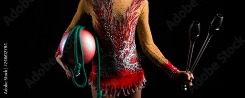 Teenager girl gymnast holding in her hands the accessories for rhythmic gymnastics