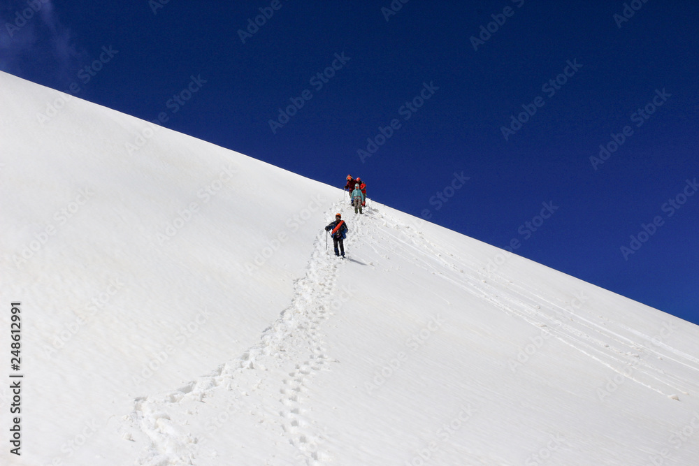 Tourists descend from the snow-capped peaks