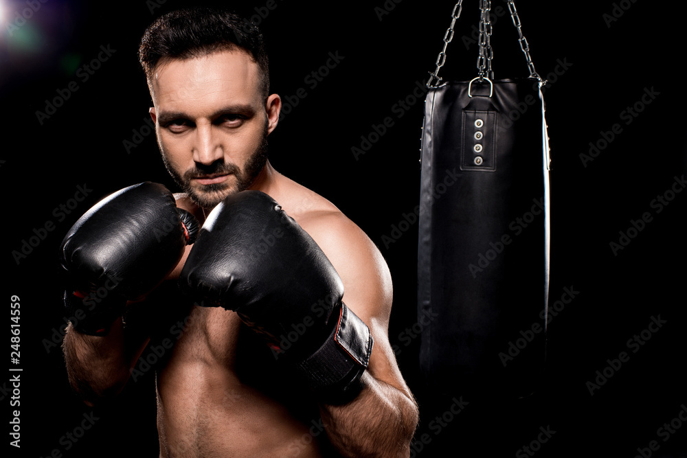 handsome sportsman wearing boxing gloves standing in boxing poseon black background handsome sportsman wearing boxing gloves standing in boxing poseon black background