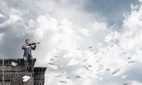 Obraz na płótnie Handsome businessman play his melody and paper planes fly around w salonie