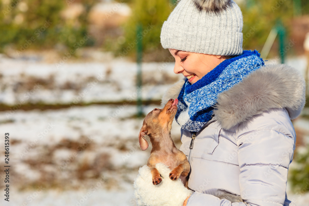 Woman playing with dog during winter Woman playing with dog during winter