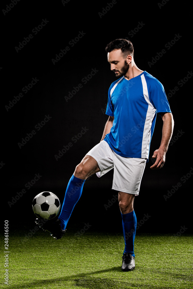 bearded man playing with ball on grass isolated on black bearded man playing with ball on grass isolated on black
