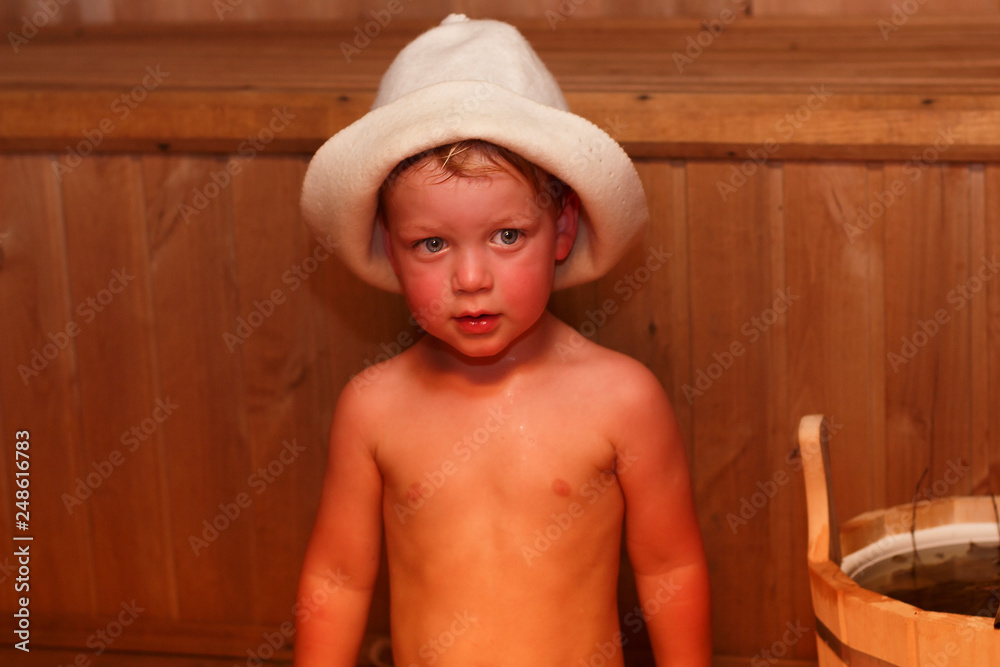 Beauty, healthcare. baby Boy relaxing in the sauna Toddler with broom and  hat in russian sauna or bath. Stock Photo