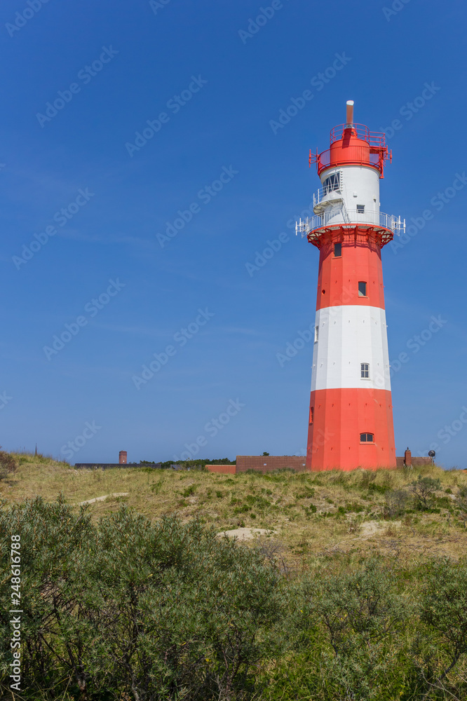 Red and white lighthouse in the dunes of Borkum, Germany