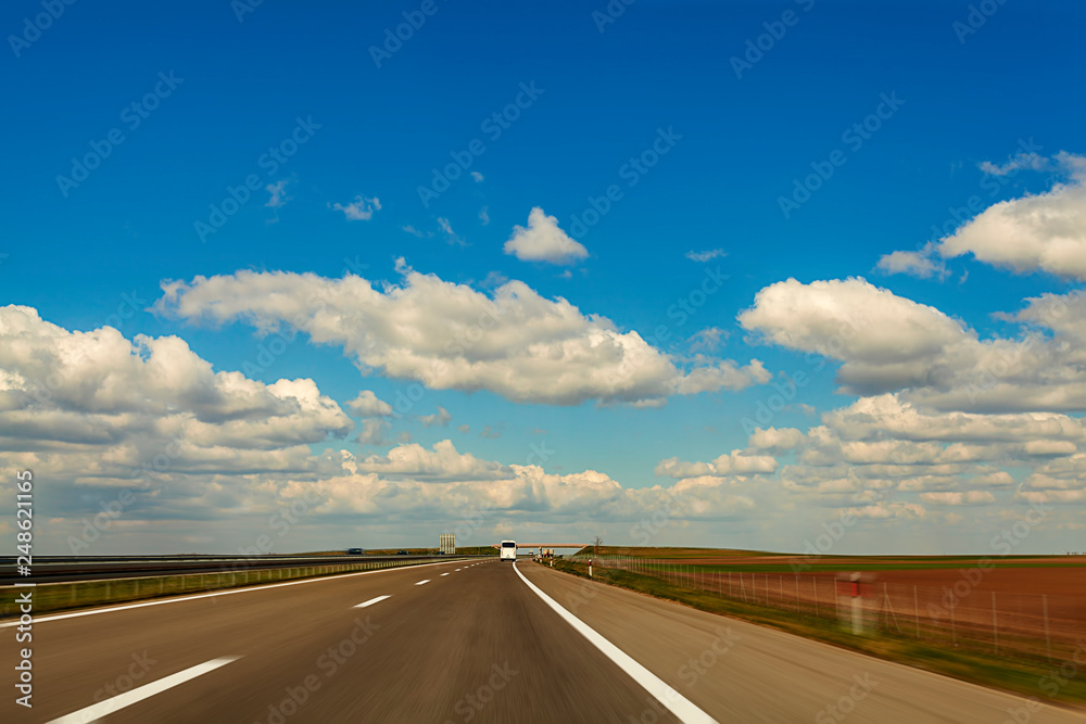 Abstract speed motion on highway background image through countryside with beautiful clouds