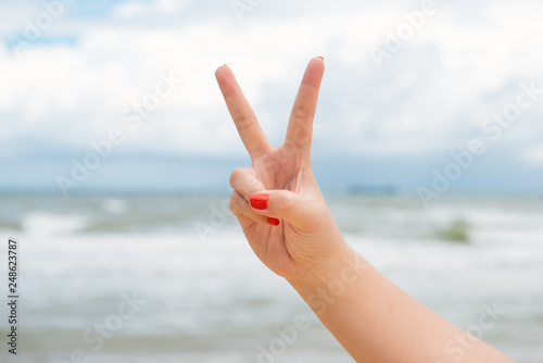 V sign victory concept at the sea.Feeling fresh.The atmosphere is refreshing and relaxing. © makistock