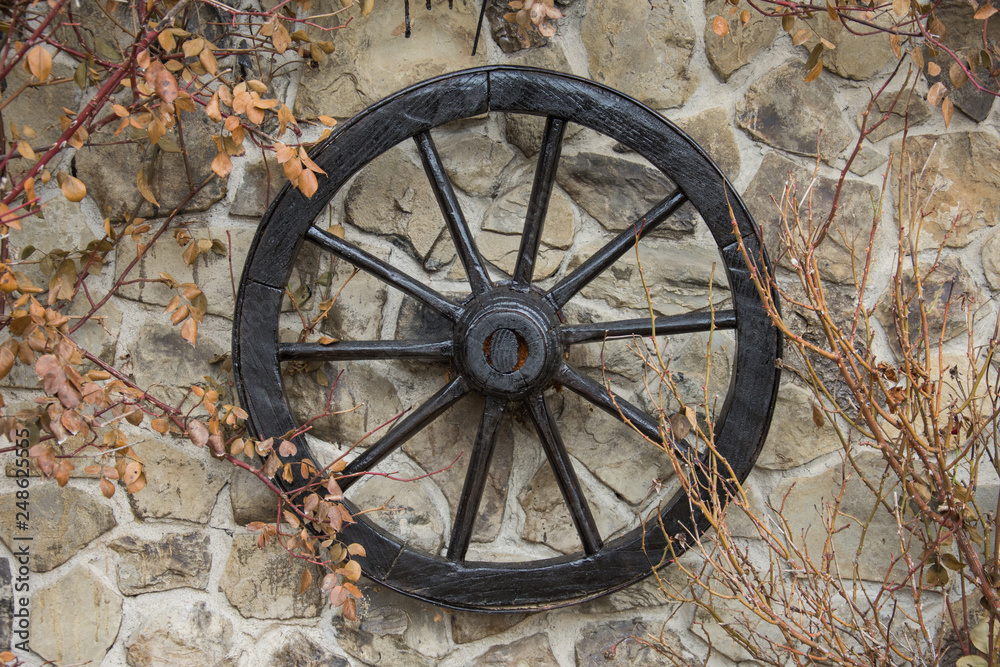 Old wooden wheel on the wall ,autumn